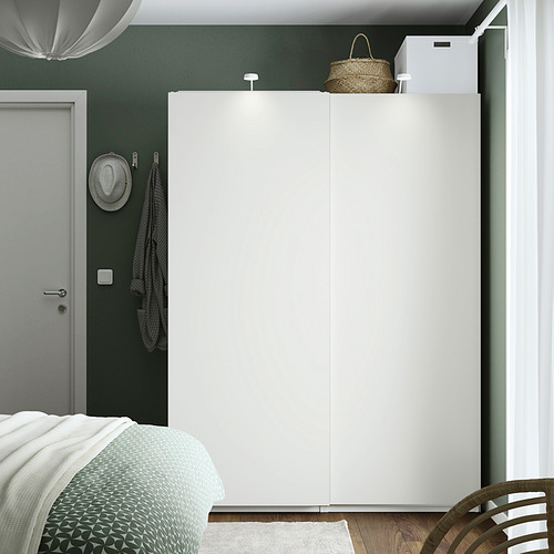 Dormitorio moderno con gran armario blanco PAX, paredes verdes, cama gris, sombrero colgante, silla y cesta en la parte superior.