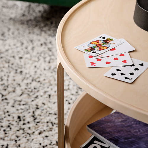 Naipes en una elegante mesa auxiliar de madera clara con bordes curvos.