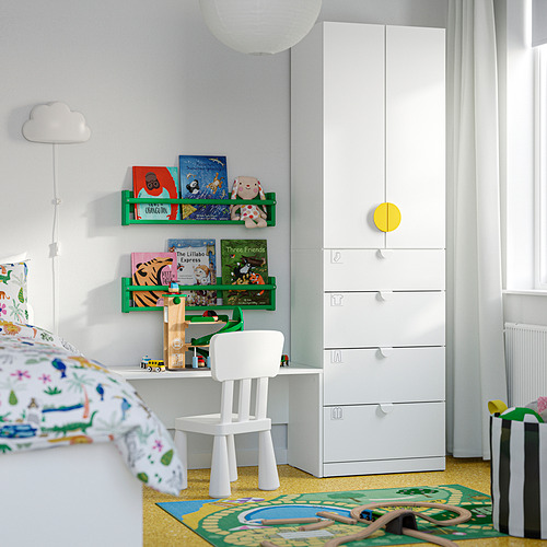 Habitación infantil con cajones blancos de LASTARE , silla pequeña y libros coloridos. Paredes grises, alfombra vibrante, rincón acogedor para leer.