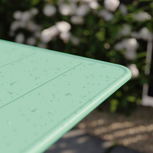 Tablero de metal plegable verde con gotas de agua, en el exterior.