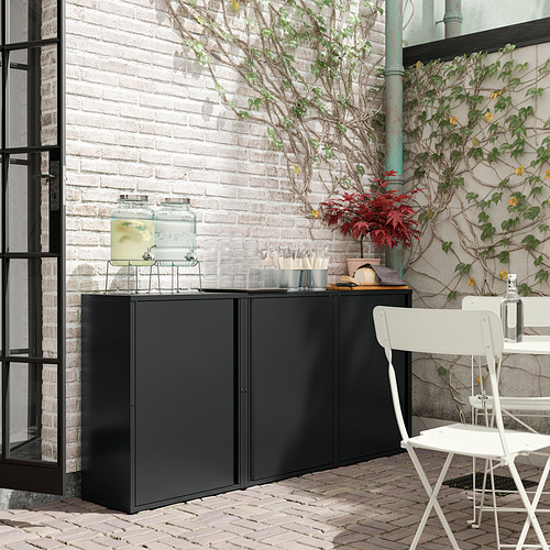 Mueble de exterior de metal negro con tapa de cristal y plantas. Perfecto para almacenamiento y decoración.