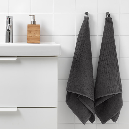 Dos toallas VÅGSJÖN en ganchos cerca del fregadero: baño y mano, algodón suave.