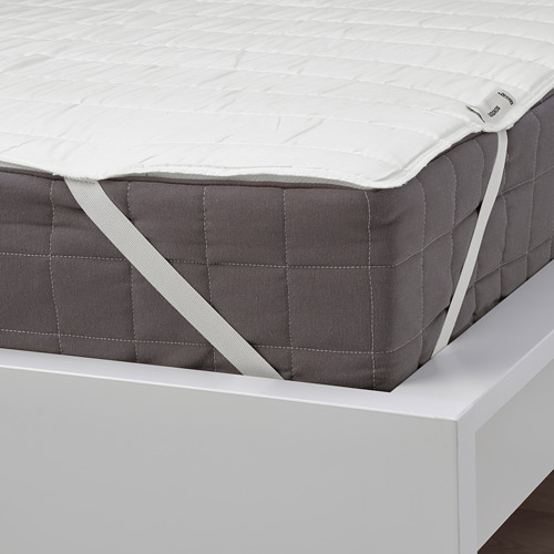 Un protector de colchón ajustado con esquinas elásticas en una cama, que muestra un ajuste seguro.