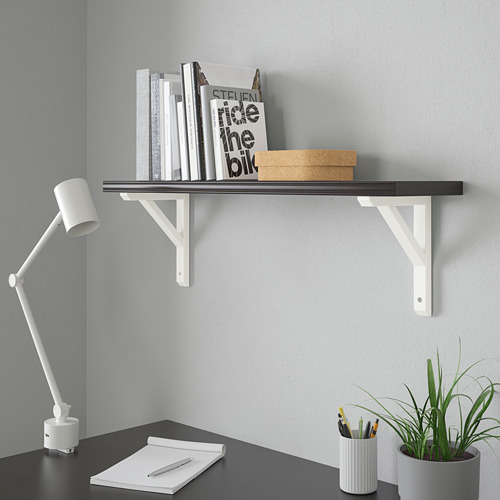 Moderna configuración minimalista de oficina en casa: estante negro, escritorio blanco, lámpara, cuaderno, bolígrafos, planta.