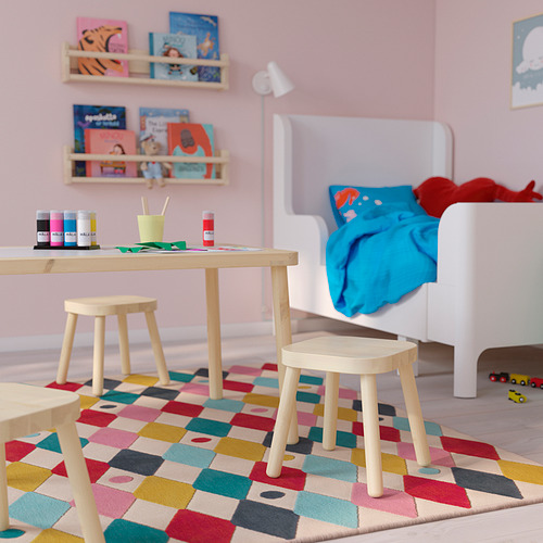 Habitación para niños con mesa y taburetes FLISAT. Madera clara, tamaño pequeño, alfombra colorida. Libros y juguetes cerca.