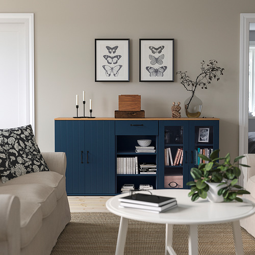Moderno salón con aparador, sofá y mesa de centro azul SKRUVBY, adornado con estampados de mariposas.