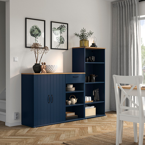 Aparador y estantería SKRUVBY azul en el moderno comedor. Sostiene artículos decorativos y utensilios de cocina, contra la pared con cuadros y ventanas.