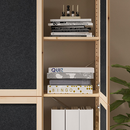 Una estantería de madera clara contiene una variedad de juegos y libros. Mueble de almacenaje funcional con estantes ajustables.