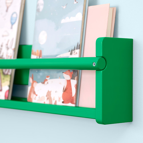 Estante de madera verde montado en la pared azul claro con un libro ilustrado a colores y un libro rosa de pie.
