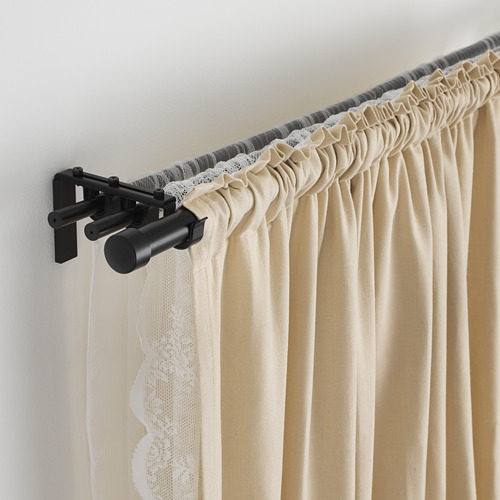 Configuración de barra de cortina triple con cortinas plisadas en riel negro ajustable.