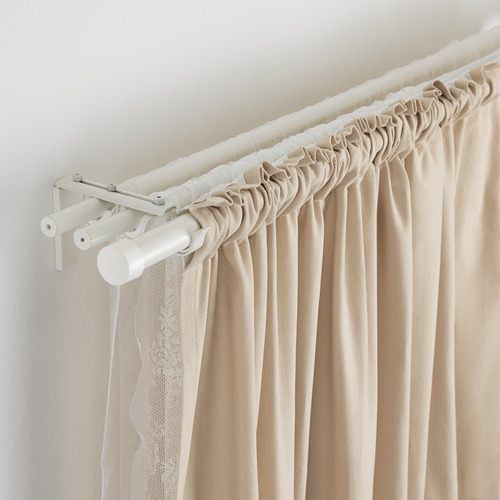 La imagen muestra barras de cortina ajustables con cortinas beige. Las varillas permiten capas y diseños de cortinas flexibles.