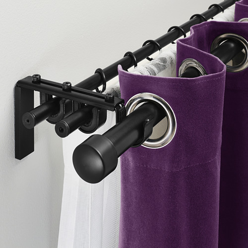 Sistema de barra de cortina negra con cortinas moradas y anillos plateados, que muestra la capacidad de triple barra para cortinas en capas.