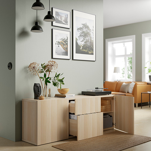 Moderno aparador de madera clara con estantes y cajones ajustables, con elementos decorativos y fotos enmarcadas.