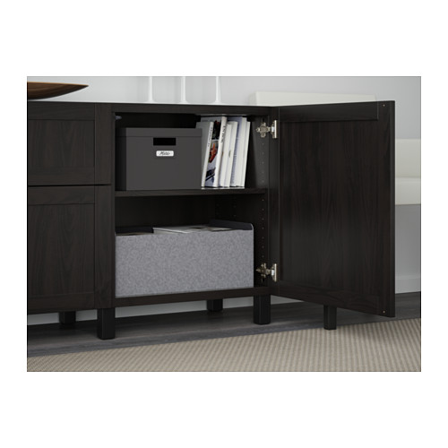 Open wooden cabinet, showing adjustable shelves with gray storage boxes and books.