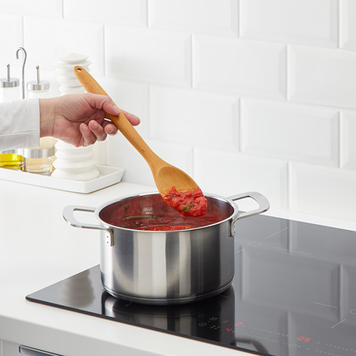 Cocinar salsa roja en estufa negra