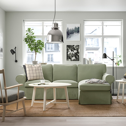 Modern living room with green EKTORP sectional, white coffee table, large windows, and hanging lamp.