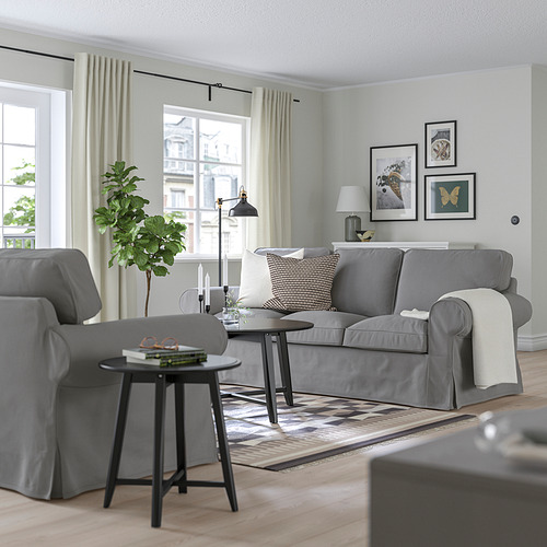 Sofá y sillón EKTORP gris, alfombra estampada, mesas auxiliares, arte de pared.