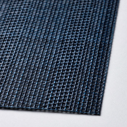 Un primer plano de un mantel individual FLYGFISK texturizado en azul oscuro, que muestra su material plástico de tejido apretado.