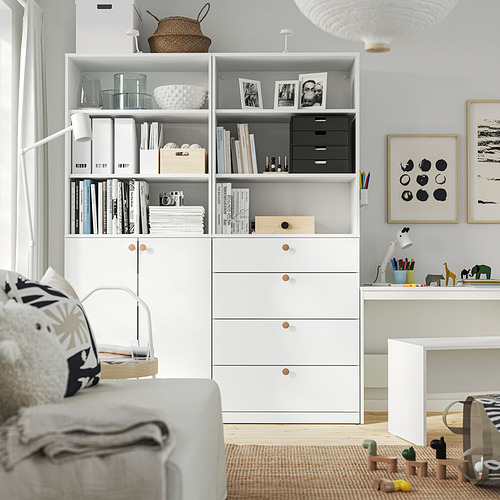 Salón con estantería blanca, escritorio y sillón acolchado.