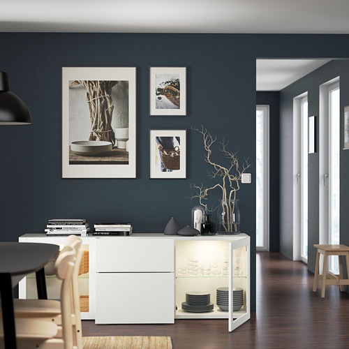 Comedor con paredes azul oscuro, muebles blancos, decoración y fotos.