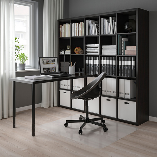 Moderna configuración de escritorio KALLAX negro, que incluye estantería con libros, computadora portátil y silla.