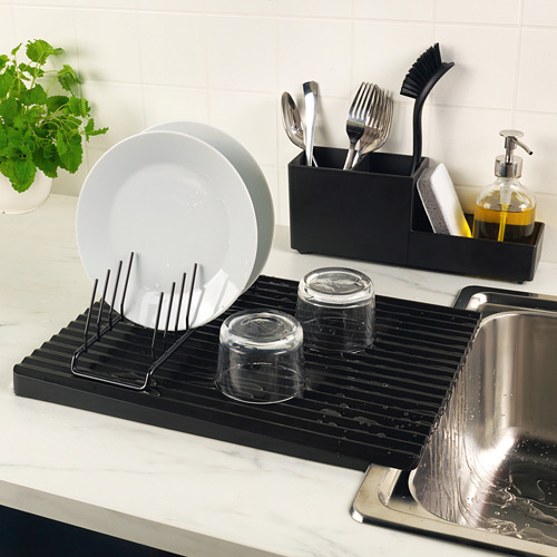Configuración del fregadero de la cocina con rejilla de secado RINNIG que sostiene platos, vasos y cubiertos. Incluye dispensador de jabón y esponja.