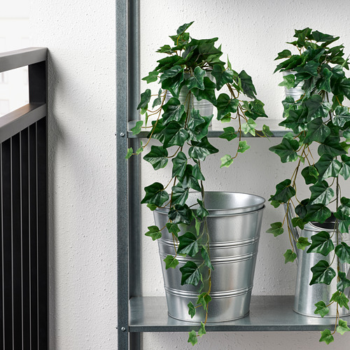 Plantas artificiales en macetas en estante metálico, aptas para uso en interiores o exteriores.