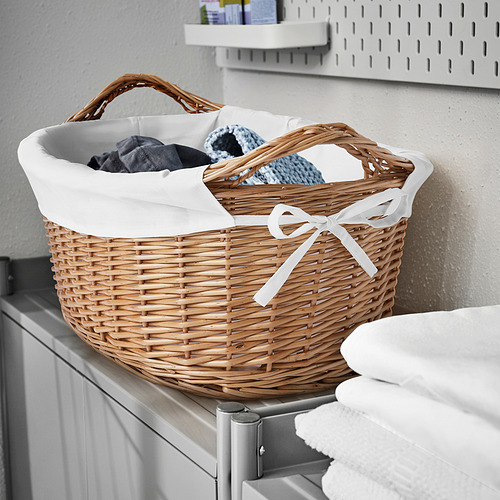 Cesta de lavandería de mimbre TOLKNING, beige, forrada con tela blanca, se adapta perfectamente a la ropa, colocada en el estante con toallas.