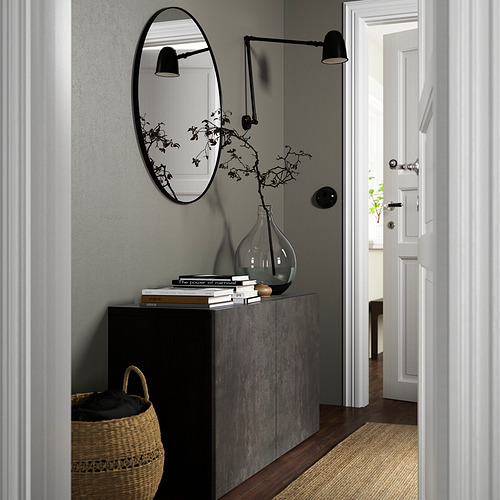 Modern hallway with BESTÅ gray sideboard, round mirror, wall lamp, wicker basket, and dried plant.