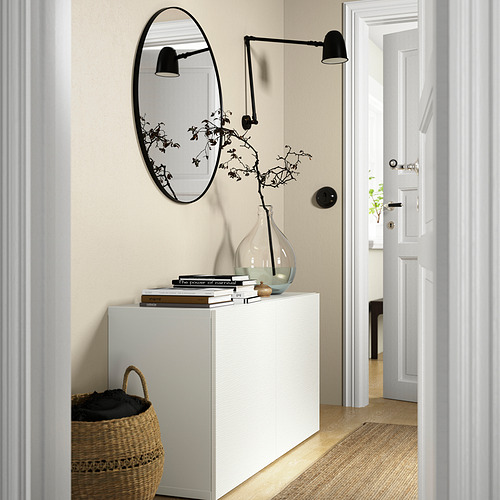Pasillo moderno: un aparador blanco BESTÅ con un espejo negro ovalado y lámparas de pared, bien dimensionadas para el espacio estrecho.