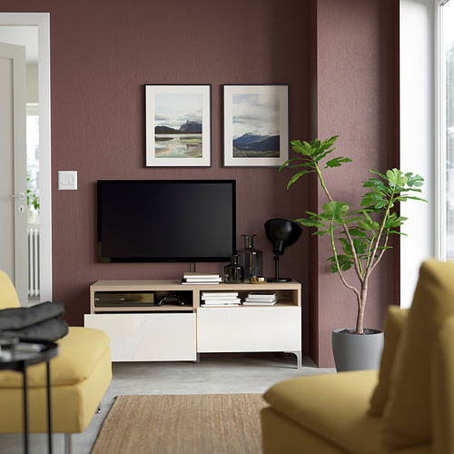 Modern living room: tv on stand, plant, yellow chairs.