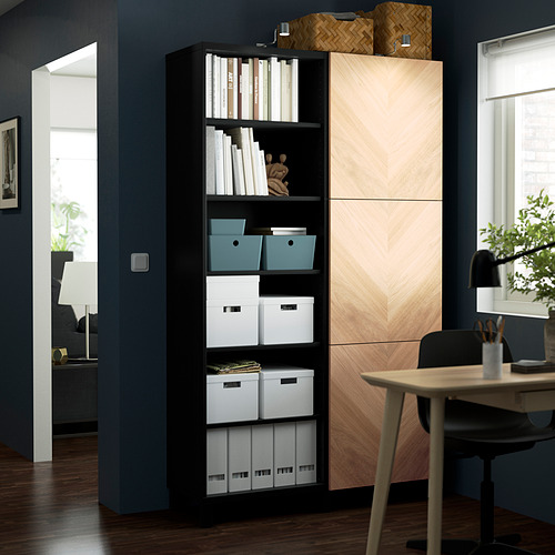 Mueble de almacenaje BESTÅ negro con estantes abiertos y armarios cerrados, cajas organizadas contra la pared azul oscuro.