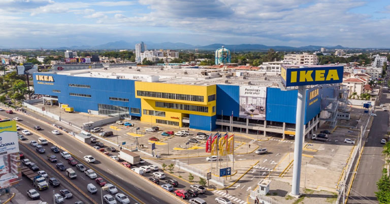 Aerial view of the blue and yellow IKEA store building next to a busy avenue.