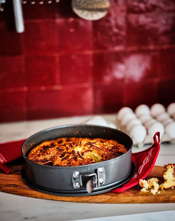Warm kitchen prep scene with FASCINERA cutting board.