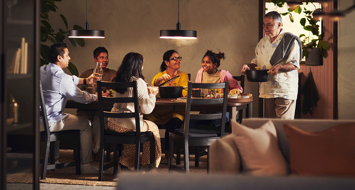  Familia de varias generaciones comparte una comida en torno a la mesa en un comedor cálido y acogedor.