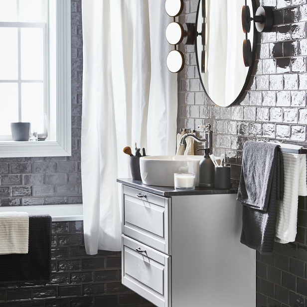 A bathroom with fresh tones featuring a TÄNNFORSEN/TÖRNVIKEN cabinet with sink and drawers, a LINDBYN mirror, and VÅGSJÖN towels on the right.