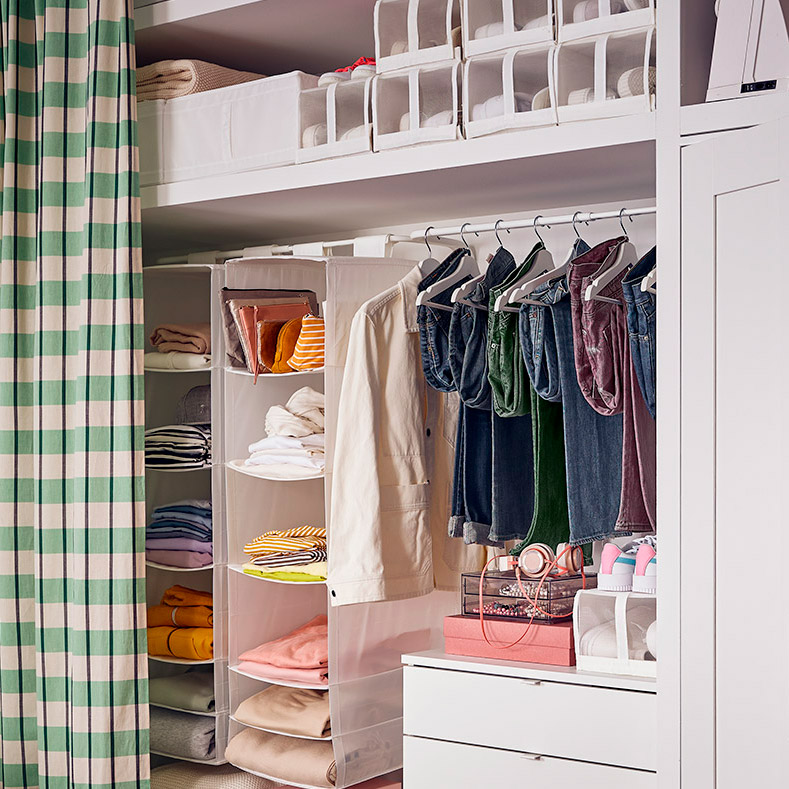 Open wardrobe with curtain, neatly arranged shelves, hanging space, and textile storage.