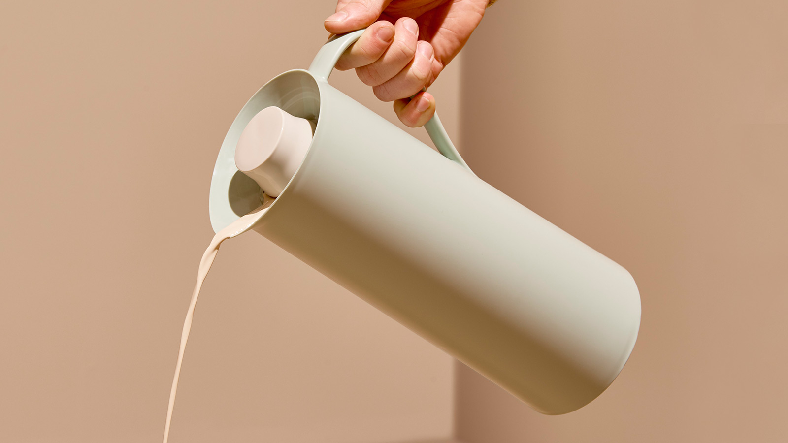 a thermal jug pouring milk