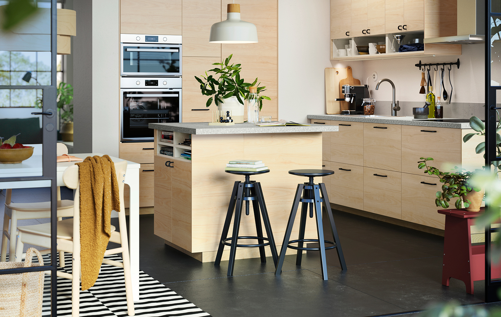 Spacious modern kitchen with wood veneers, there is a kitchen island with high stools.