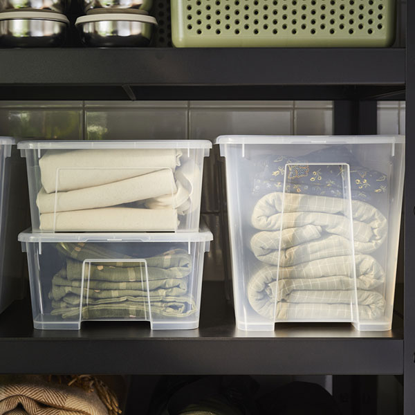 A shelving unit with two SAMLA boxes filled with towels and an UPPRÄMEN storage basket.