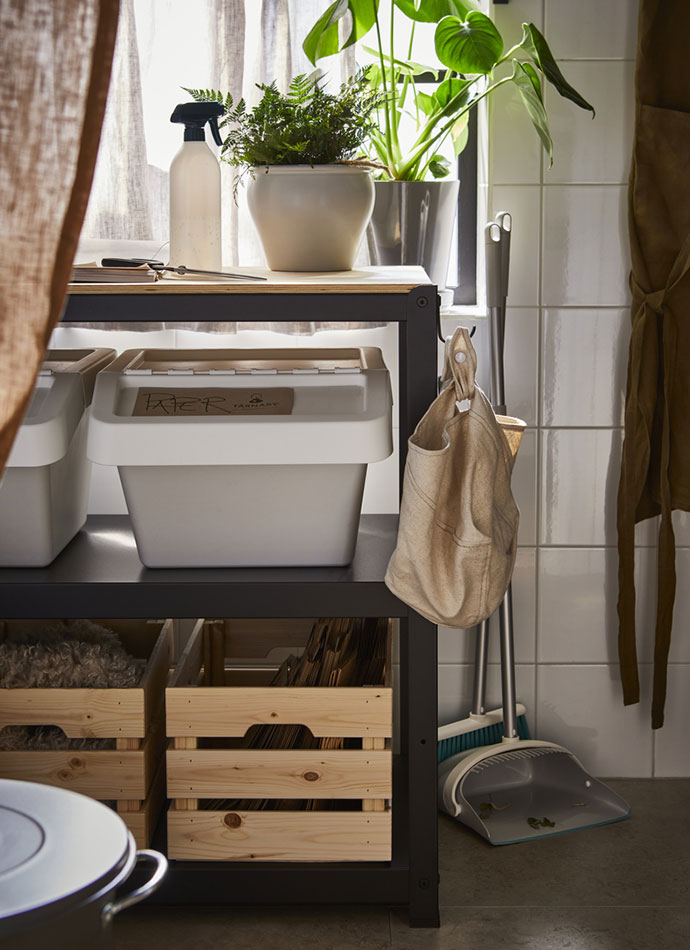 A BROR utility cart filled with a SORTERA recycling bin, KNAGGLIG boxes with AMBRARÖNN plant pots on top, next to PEPPRIG dustpans.