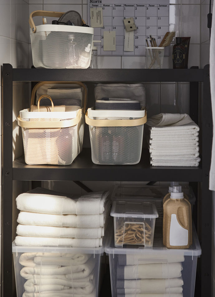 A BROR shelving unit loaded with SAMLA boxes, a RISATORP wire basket, and FREDRIKSJÖN bath towels.