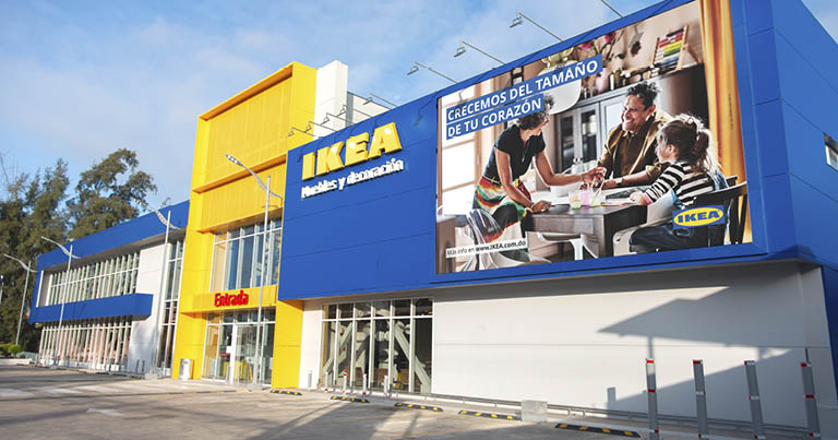 Blue and yellow IKEA store facade with a family advertisement billboard and the main entrance.