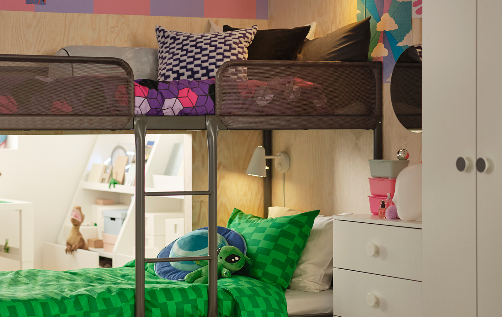 Modern bunk beds with green and purple bedding, and a light wood wall. A fun and youthful ambiance in a shared bedroom.