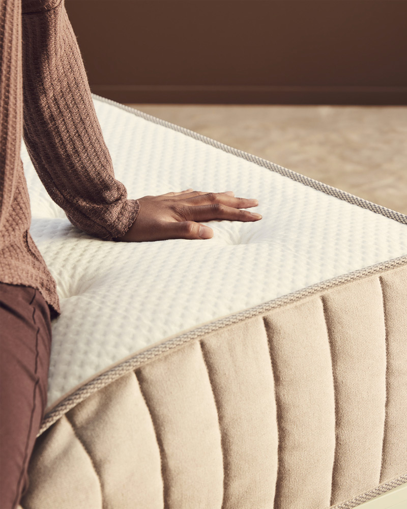 Woman sitting on a mattress.