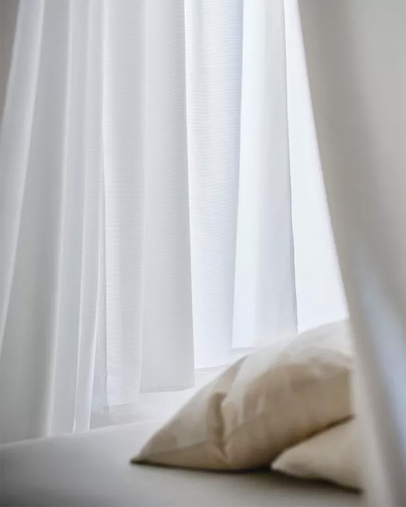 DVALA pillows and TIBAST curtains.