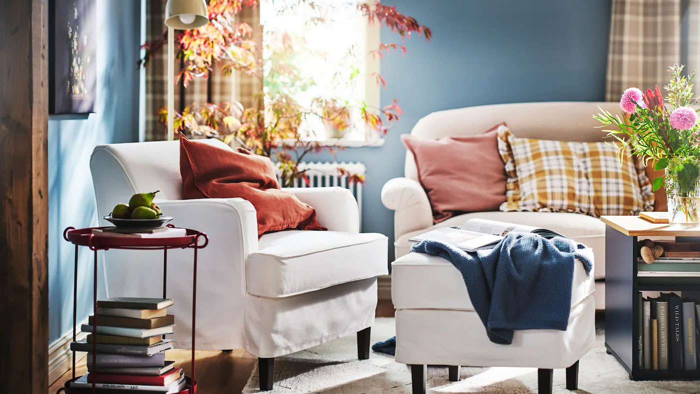 Traditional style reading corner with comfortable chair, cushions and blankets, candles and flowers for a relaxing atmosphere