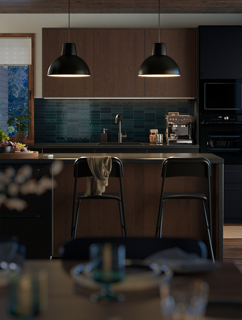 Cocina moderna con gabinetes de madera oscura, azulejos turquesa y dos lámparas colgantes negras. Un ambiente elegante y cálido.
