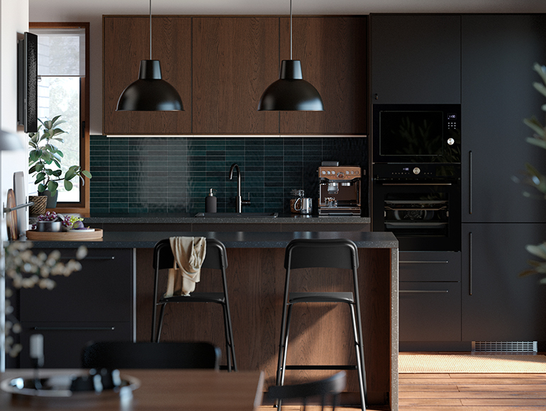 Cocina moderna con gabinetes oscuros y de madera. Azulejos azules y lámparas colgantes negras.