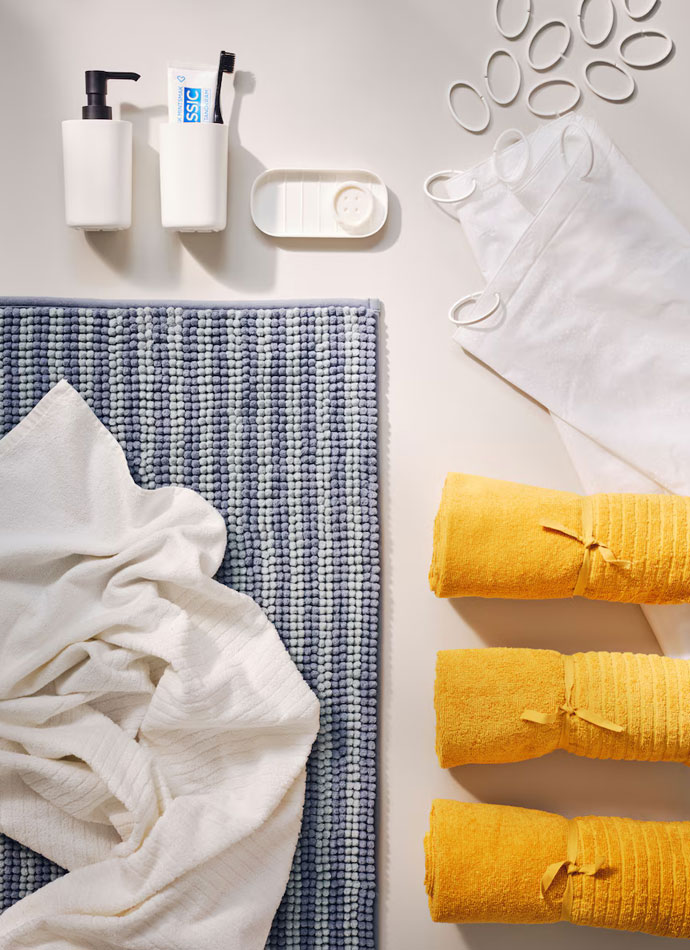 Bathroom articles such as towels, soap dispensers in mustard yellow and griss colors